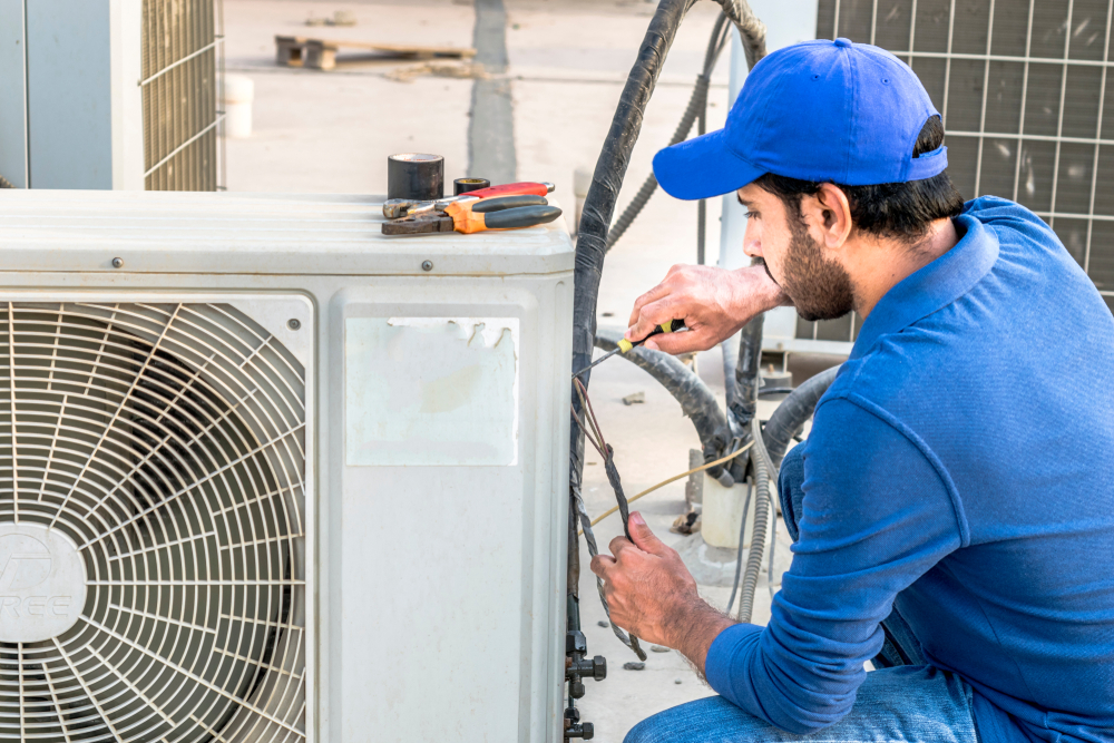 A,professional,electrician,man,is,fixing,the,heavy,air,conditioner