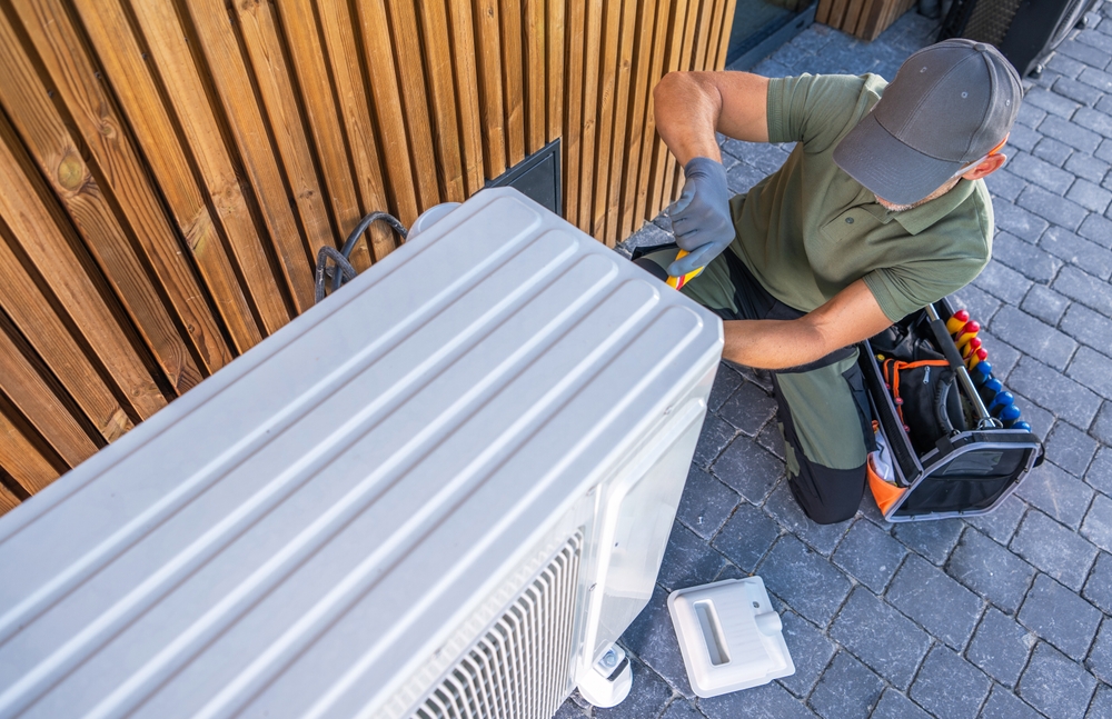 A,technician,works,on,an,air,conditioning,unit,,using,tools
